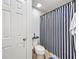 Cozy bathroom features a toilet and shower with a blue and white striped curtain at 661 Black Eagle Dr, Groveland, FL 34736