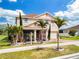 Charming two-story home with well-maintained landscaping, including palm trees, enhancing the curb appeal at 661 Black Eagle Dr, Groveland, FL 34736
