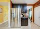 Modern kitchen boasting stainless steel refrigerator, black cabinets, granite counters, and stylish tile flooring at 661 Black Eagle Dr, Groveland, FL 34736