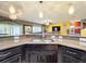 Open concept kitchen with stainless steel sink, granite counters, pendant lighting and bar seating at 661 Black Eagle Dr, Groveland, FL 34736