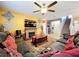 Stylish living room features a fireplace, large screen TV, comfortable seating and a ceiling fan at 661 Black Eagle Dr, Groveland, FL 34736