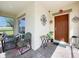Quaint front porch featuring cozy seating area, perfect for relaxing and enjoying the outdoors at 661 Black Eagle Dr, Groveland, FL 34736