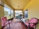 Charming screened-in porch with cozy seating and views of the backyard, creating an ideal space for relaxation at 661 Black Eagle Dr, Groveland, FL 34736
