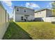 Spacious backyard featuring a well-maintained lawn, white fence, and outdoor grilling area at 728 Trotters Dr, Eagle Lake, FL 33839