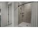 Updated bathroom with tiled walk-in shower, rainfall shower head, and linen curtain at 728 Trotters Dr, Eagle Lake, FL 33839