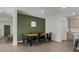 Dining room with a statement green accent wall and rustic wooden table with black metal chairs at 728 Trotters Dr, Eagle Lake, FL 33839