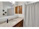 Bathroom showcasing a granite vanity, framed mirror, and tub with tiled surround and shower curtain at 7947 Lake James Blvd, Lakeland, FL 33810
