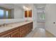 Bathroom vanity with double sinks and granite countertop next to doorway view to a bedroom at 7947 Lake James Blvd, Lakeland, FL 33810