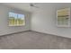 Bedroom featuring carpet, two windows providing natural light, and a ceiling fan at 7947 Lake James Blvd, Lakeland, FL 33810