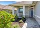 Inviting front porch with beautiful landscaping, stone accents, and a cozy seating area at 7947 Lake James Blvd, Lakeland, FL 33810
