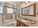 Well-lit bathroom featuring granite countertop, framed mirror, and shower-tub combination at 914 Christina Chase Dr # Drive, Lakeland, FL 33813
