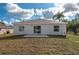 View of backyard featuring a small patio, sliding glass door, and partial fencing at 1013 Rhodes S Rd, Haines City, FL 33844