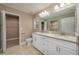 Bathroom with double vanity, granite counters, walk-in closet, and tiled floors at 1013 Rhodes S Rd, Haines City, FL 33844