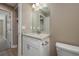 A bathroom with granite countertop vanity, white cabinets, a large mirror, and neutral walls at 1013 Rhodes S Rd, Haines City, FL 33844