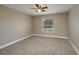Bright bedroom with neutral carpet and a window overlooking the backyard at 1013 Rhodes S Rd, Haines City, FL 33844