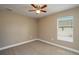 Bedroom features neutral carpet, a window, and a ceiling fan at 1013 Rhodes S Rd, Haines City, FL 33844
