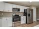 Updated kitchen with stainless steel appliances, white cabinetry, and stone countertops at 1013 Rhodes S Rd, Haines City, FL 33844