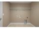 Empty laundry room featuring light walls, tile flooring, and a wire shelf at 1013 Rhodes S Rd, Haines City, FL 33844