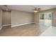 Bright living room with wood floors, ceiling fan, and sliding glass doors to the backyard at 1013 Rhodes S Rd, Haines City, FL 33844