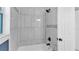 Bright bathroom features a shower-tub combo, white marble-like tile surround, and updated fixtures at 1028 W Marjorie St, Lakeland, FL 33815