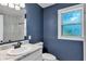 Renovated blue bathroom featuring a walk-in shower, new fixtures, and a window at 1028 W Marjorie St, Lakeland, FL 33815