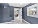 Hallway leading into the kitchen, featuring blue walls, tile flooring, and natural light at 1028 W Marjorie St, Lakeland, FL 33815