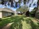 Spacious backyard with lush green grass and mature trees, perfect for outdoor activities at 10812 Versailles Blvd. Blvd, Clermont, FL 34711