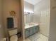 Bathroom with a soft blue vanity, decorative rug, and neutral paint color at 10812 Versailles Blvd. Blvd, Clermont, FL 34711