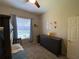 Neutral toned bedroom featuring a ceiling fan and a large dresser with themed wall art above at 10812 Versailles Blvd. Blvd, Clermont, FL 34711