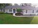 Charming single-story home featuring a manicured front lawn and beautiful landscaping at 10812 Versailles Blvd. Blvd, Clermont, FL 34711