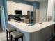 Modern kitchen featuring white cabinets, stainless steel appliances, and breakfast bar with seating at 10812 Versailles Blvd. Blvd, Clermont, FL 34711