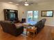 Spacious living room featuring hardwood floors, comfortable seating, and access to the patio at 10812 Versailles Blvd. Blvd, Clermont, FL 34711