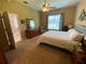 Spacious main bedroom features neutral tones, carpeted floors, a ceiling fan and a window allowing natural light at 10812 Versailles Blvd. Blvd, Clermont, FL 34711