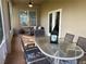 Brick patio featuring glass table with surrounding chairs, and an outdoor couch under string lights at 10812 Versailles Blvd. Blvd, Clermont, FL 34711