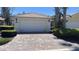 Charming home featuring a brick driveway, two car garage, and well manicured landscaping at 11953 Delfina Ln, Orlando, FL 32827