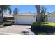 Charming home with a brick driveway, a two car garage, and lush, tropical landscaping at 11953 Delfina Ln, Orlando, FL 32827
