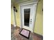 A welcoming front door with decorative trim, stylish doormat, and colorful brick walkway creates curb appeal at 11953 Delfina Ln, Orlando, FL 32827