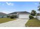 Charming single-story home with a well-manicured lawn and a two-car garage on a sunny day at 120 Flatfish Ct, Kissimmee, FL 34759