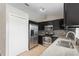 Modern kitchen with stainless steel appliances, granite countertops, and dark cabinetry at 120 Flatfish Ct, Kissimmee, FL 34759