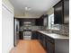 Modern kitchen featuring dark cabinetry, granite countertops, tile backsplash, and stainless steel appliances at 120 Flatfish Ct, Kissimmee, FL 34759