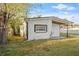 Rear view of the home, showcasing its simple architectural design and side yard at 126 Mason St, Auburndale, FL 33823