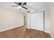 Bedroom featuring wood laminate flooring, closet, neutral walls and trim, with a ceiling fan at 126 Mason St, Auburndale, FL 33823