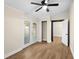 This bedroom features a ceiling fan, wood-look floors, and french doors to the outside at 126 Mason St, Auburndale, FL 33823