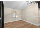 Bedroom featuring wood laminate flooring and trimwork, with natural light from one window at 126 Mason St, Auburndale, FL 33823