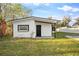 Home exterior, highlighting the white paint, black trim and door, and freshly cut grass at 126 Mason St, Auburndale, FL 33823