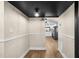 View of the hallway with black ceiling and wood laminate flooring, leading into the kitchen at 126 Mason St, Auburndale, FL 33823
