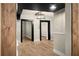 Hallway featuring wood laminate flooring, black doorframes, and neutral colored walls and baseboards at 126 Mason St, Auburndale, FL 33823