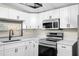 Bright kitchen with stainless steel appliances, white cabinets, and quartz countertops at 126 Mason St, Auburndale, FL 33823