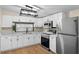 Well-lit kitchen with stainless steel appliances and white cabinets and counters at 126 Mason St, Auburndale, FL 33823