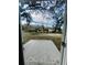 View of backyard with mature trees and room for outdoor activities from the doorway at 1522 Kettles Ave, Lakeland, FL 33805